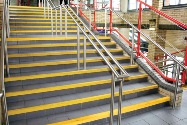 Yellow grippy stair nosings on large set of stair edges