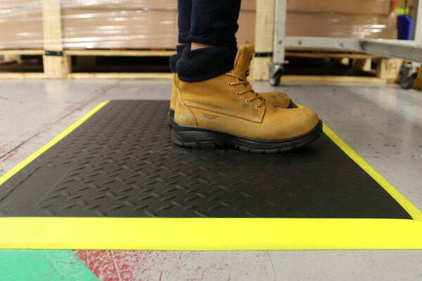 Woman standing on a black and yellow Electrostatic Discharge Mat with Diamond detailing