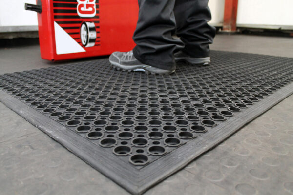 Man standing on a black Honeycombed Detailing mat