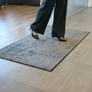 Woman walking on a beige microfibre washable doormat in high heels