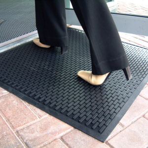 Woman standing on an outdoor entrance mat