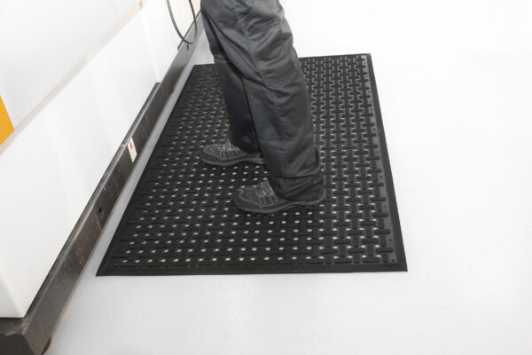 Person standing on black Rubber Anti-Fatigue mat with X detailing