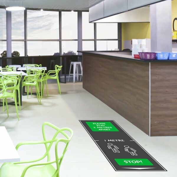 Green 'please stay 2 metres apart' mat in cafeteria
