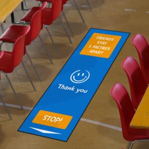 Blue and orange 'friends state 2 metres apart' mat around classroom chairs