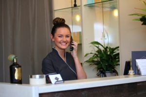 Receptionist at a spa with a smile talking on the phone